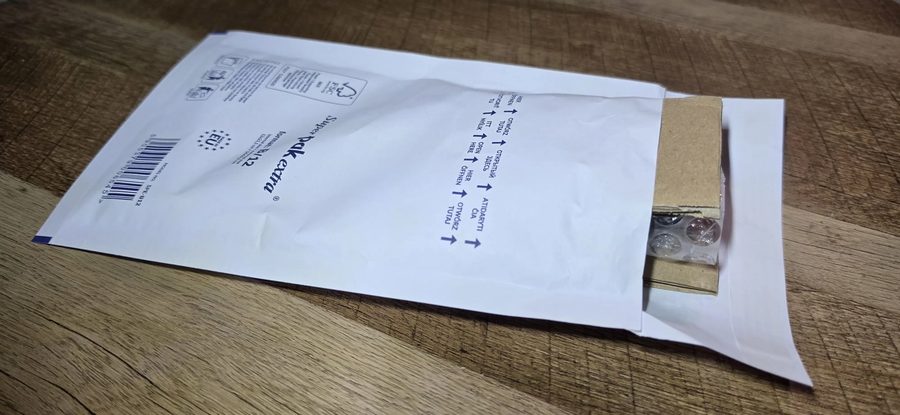 Zapakowany kluczyk wsuwany do koperty bąbelkowej